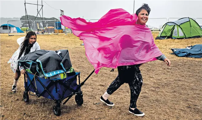  ??  ?? Heading home: festival-goers pack their bags after high winds and torrential rain brought an early end to this year’s Camp Bestival in Dorset