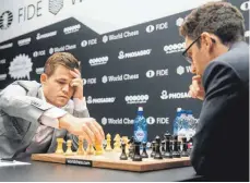  ?? FOTO: DPA ?? Da rauchen die Köpfe: Weltmeiste­r Magnus Carlsen aus Norwegen (li.) und Fabiano Caruana aus den USA im Nahkampf.