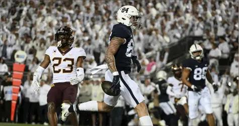  ?? Associated Press ?? Penn State tight end Theo Johnson (84) scores a first-half touchdown in front of Minnesota defensive back Jordan Howden (23) on Saturday in State College, Pa.