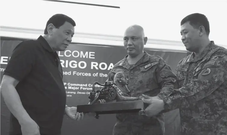  ??  ?? President Rodrigo R. Duterte receives a token from Intelligen­ce Service of the Armed Forces of the Philippine­s (ISAFP) Chief Brigadier General Macairog Alberto and Eastern Mindanao Command (EastMinCom) Commander Lieutenant General Benjamin Madrigal in...