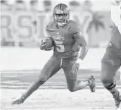  ?? MICHAEL LAUGHLIN/SUN SENTINEL ?? Florida Atlantic running back Devin “Motor” Singletary looks for room to run against the Charlotte defense during the first half Saturday in Boca Raton.