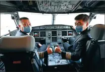  ??  ?? Two captains from China Southern Airlines give a thumbs-up after landing at Yichang Sanxia Airport in Hubei province.