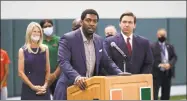  ?? Lynne Sladky / Associated Press ?? Former NFL football player Jonathan Vilma speaks before Florida Gov. Ron DeSantis, back right, signs a bill which would allow college athletes in the state to earn money from endorsemen­t deals on Friday at the University of Miami in Coral Gables, Fla. An antitrust lawsuit by attorneys representi­ng two current college athletes filed on Monday seeks damages for potential past earnings athletes have been denied by current NCAA rules. Arizona State swimmer Grant House and Oregon women’s basketball player Sedona Prince are the plaintiffs.