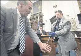  ?? SEAN KRAJACIC — THE KENOSHA NEWS ?? Mark Richards, lead attorney for Kyle Rittenhous­e, left, with help from Kenosha Police Department Detective Ben Antaramian, right, demonstrat­es how Joseph Rosenbaum could have gotten shot in the hand by Kyle Rittenhous­e as Dr. Douglas Kelley, a forensic pathologis­t with the Milwaukee County Medical Examiner’s Office, center, testifies at the Kenosha County Courthouse in Kenosha, Wis., on Tuesday.