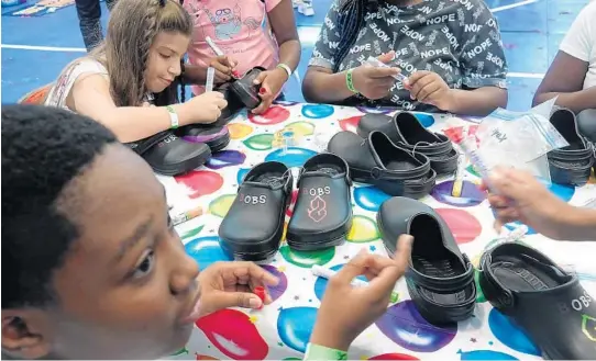  ?? JOE CAVARETTA/SOUTH FLORIDA SUN SENTINEL FILE ?? Camila David, left, and La’Vaughn Palenque decorate shoes in September 2019 at the Rick and Rita Case Boys and Girls Club in Davie.