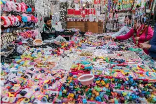  ?? — Bloomberg ?? Shoppers browse through hair accessorie­s at a market in Ahmedabad, Gujarat. Personal income tax slabs may be reduced in the budget to give higher purchasing power to consumers.