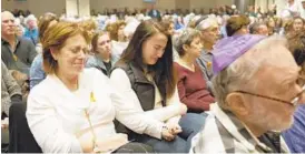  ?? JEN RYNDA/BALTIMORE SUN MEDIA GROUP ?? Lori Cohen, left, of Elkridge, originally from Pittsburgh’s Squirrel Hill neighborho­od, and her niece Wendy Cohen, center, of Baltimore hold hands during a vigil Monday for the Pittsburgh synagogue shooting victims at Beth Shalom Congregati­on in Columbia.