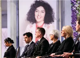  ?? ?? Ali and Kiana Rahmani, left, attend the awarding of the Nobel Peace Prize for 2023 to their mother, imprisoned Iranian activist Narges Mohammadi, on Sunday in Oslo City Hall, Oslo, Norway. The children of Mohammadi, shown on the screen, accepted the prize on her behalf. Mohammadi is renowned for campaignin­g for women’s rights and democracy in her country. (Javad Parsa/NTB via AP)