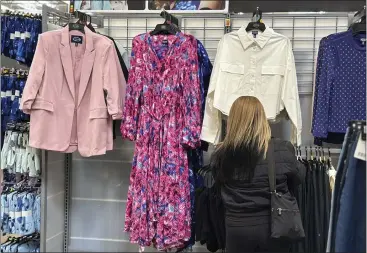  ?? ANNE D'INNOCENZIO — THE ASSOCIATED PRESS ?? A shopper looks at clothes at a Walmart store in Secaucus, N.J., on March 25. On Monday, the Commerce Department reported that U.S. retail sales data for March showed a surge of 0.7%.