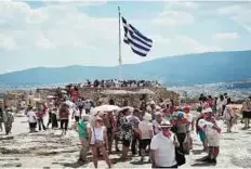  ??  ?? Tourists at the Acropolis in Athens yesterday. Foreign visitors may be forced to cut their holidays short if they are unable to pay for meals and services.