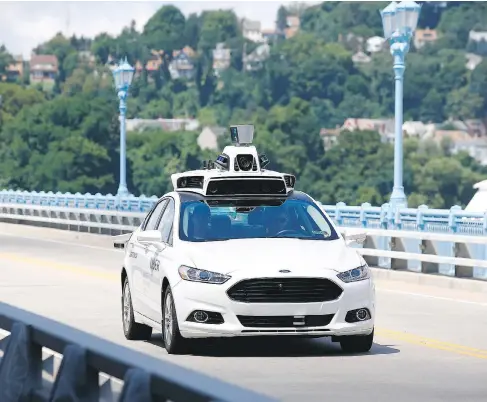  ?? JARED WICKERHAM / THE ASSOCIATED PRESS FILES ?? Uber employees ride in a self-driving car in Pittsburgh, which, with its hills and older streets, will become the first American city to experiment with the company’s driverless-car service. Uber has been conducting road tests since May, but details of...