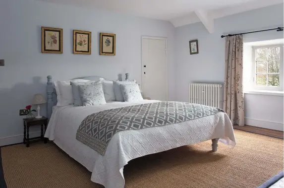  ??  ?? Above: Emma painted the wooden bedstead to match the walls in the master bedroom – Gauze Mid by Little Greene. The rug on the bed is from H&M, and the coir rug is from Crucial Trading, edged in navy linen. The curtains are from The Curtain Exchange and the pale blue cushions are by Sophie Allport