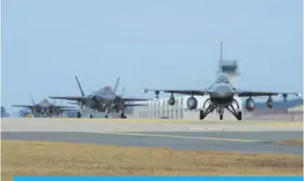  ?? —AFP ?? GUNSAN: Photo shows US Air Force F-16 Fighting Falcon (right) and F-35A Lightning II fighter jets taxiing at Kunsan Air Base in the southweste­rn port city of Gunsan. The US and South Korea kicked off their largest ever joint air exercise yesterday.