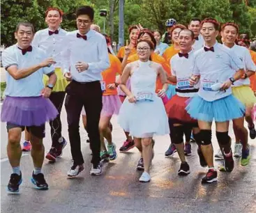  ?? FOTO: ZUHAIRI ZUBER ?? PASANGAN pengantin baru Cho dan Lim berlari diiringi rakan yang memakai skirt.