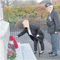  ??  ?? Family Agnes Fotheringh­am lays a wreath to her brother Charles McLaren, watched by his friend, Tam Balloch