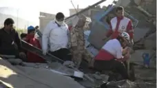  ?? FARZAD MENATI/AFP/GETTY IMAGES ?? Rescue workers search for survivors amid the rubble after a magnitude 7.3 earthquake struck Sunday, causing widespread and heavy damage.