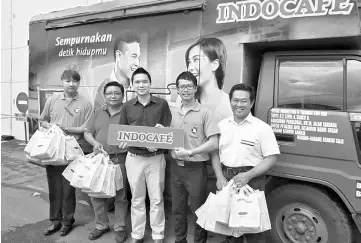  ??  ?? Regal Marketing & Trading Sdn Bhd’s area manager Goh Teck Lim (third left) handing over the instant coffee products from Indocafé to Ng for the ‘Collect Stamp, Redeem Gift’ event.