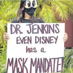  ?? JOE BURBANK/ORLANDO SENTINEL ?? A demonstrat­or holds a message for the Orange County Public Schools board during a protest in front of the OCPS headquarte­rs in downtown Orlando on Aug. 23.