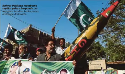  ?? [FOTO AFP] ?? Rakyat Pakistan membawa replika peluru berpandu dan mengibar bendera ketika protes anti-india di Karachi.