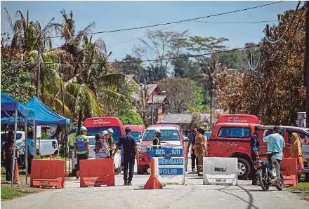  ?? (Foto BERNAMA) ?? Anggota polis berkawal di sekitar Kampung Kuala Sungai Baru bagi menyelaras kemasukan penduduk ke kediaman mereka, semalam.