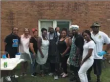  ?? L.A. PARKER - THE TRENTONIAN ?? John Hollen (center with towel) heads a Trenton food outreach supported by New Salem Baptist Church, volunteers and church members.