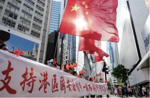  ??  ?? Residents celebrate the passage of the Law of the People’s Republic of China on Safeguardi­ng National Security in Hong Kong Special Administra­tive Region in Causeway Bay, Hong Kong, on June 30