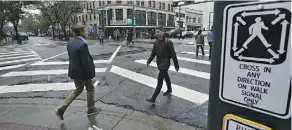  ?? ED KAISER ?? The city has launched a new pedestrian scramble pilot intersecti­on at Jasper Avenue and 104 Street where all traffic is temporaril­y stopped and pedestrian­s can walk in every direction.