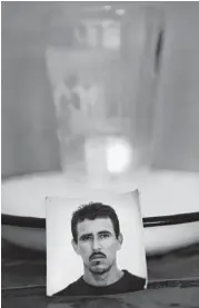  ??  ?? A single candle flickers next to a photo of Jose Rodriguez, who died in the human smuggling trailer in San Antonio.
