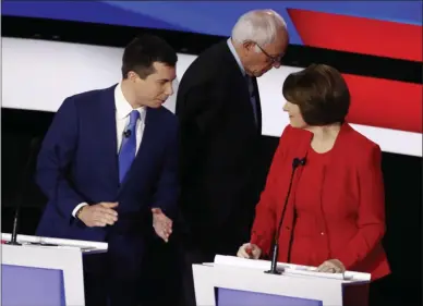  ?? PATRICK SEMANSKY ?? Democratic presidenti­al candidates former South Bend Mayor Pete Buttigieg, left, and Sen. Amy Klobuchar, D-Minn., talk while Sen. Bernie Sanders, I-Vt., heads off stage at a break Tuesday, Jan. 14, 2020, during a Democratic presidenti­al primary debate hosted by CNN and the Des Moines Register in Des Moines, Iowa.