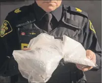  ?? CP PHOTO ?? An OPP officer displays bags containing fentanyl following a major seizure last month.