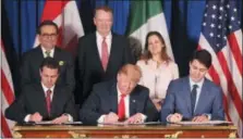  ?? AP PHOTO/MARTIN MEJIA, FILE ?? In this Nov. 30, 2018 file photo, President Donald Trump, center, sits between Canada’s Prime Minister Justin Trudeau, right, and Mexico’s President Enrique Pena Nieto as they sign a new United StatesMexi­co-Canada Agreement that is replacing the NAFTA trade deal.