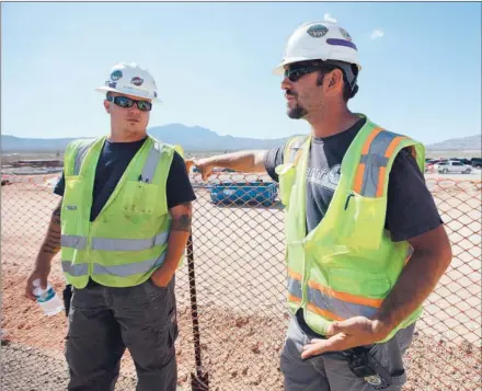  ?? JOSIE LEPE/ STAFF ?? Kenneth Platten, left, chats with Ross Bowlin, a former Marine who served two stints in Iraq at Oakland- based BrightSour­ce Energy’s Ivanpah Electric Generating System in the Mojave Desert. The veterans landed the jobs through the Helmets to Hardhats...