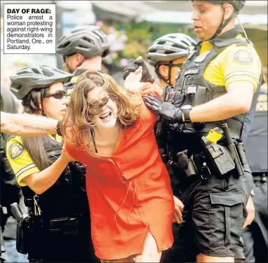  ??  ?? DAY OF RAGE: Police arrest a woman protesting against right-wing demonstrat­ors in Portland, Ore., on Saturday.