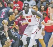  ?? ASSOCIATED PRESS FILE PHOTO ?? UNM’s Makuach Maluach, center, has taken on a more aggressive tone at both ends of the floor in the past week or so, scoring 32 points while shooting 61 percent from the floor and recording three steals.