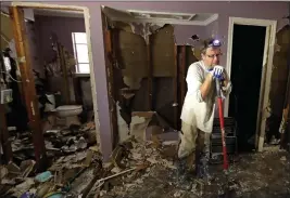  ?? Associated Press ?? n Edward Woods takes a break from cleaning up his mother’s home Sunday in Spring, Texas, which was destroyed by floodwater­s in the aftermath of Hurricane Harvey.