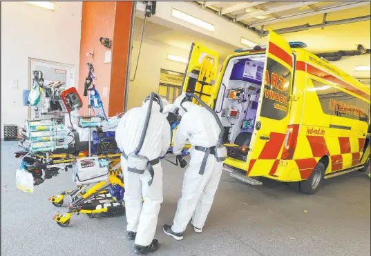  ?? Bodo Schackow The Associated Press ?? A COVID-19 patient gets prepared to be transferre­d Friday by an emergency intensive care mobile unit in Saalfeld, Germany.