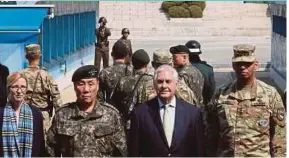  ?? AP PIC ?? United States Secretary of State Rex Tillerson (second from right) visiting the Demilitari­sed Zone in South Korea yesterday as a North Korean guard films the event in the background.
