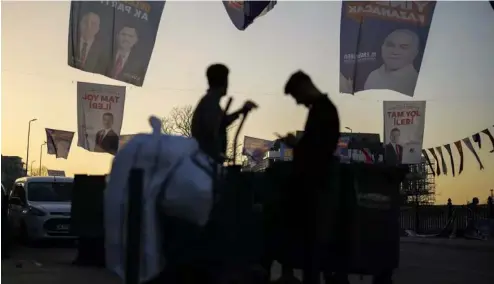  ?? ?? People walk under campaign banners of candidates for Istanbul of Justice and Developmen­t Party, or AKP, and Republican People's Party, or CHP, in Istanbul