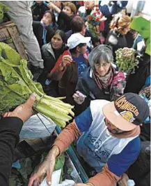  ?? Juan Mabromata/AFP ?? » DE GRAÇA Manifestan­tes distribuem verduras na Praça de Maio, em Buenos Aires, durante protesto de produtores contra a inflação e os baixos preços dos itens agrícolas