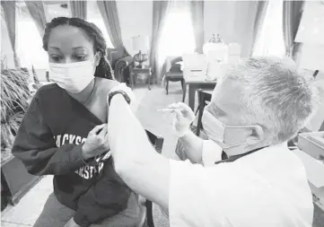  ?? ROGELIO V. SOLIS/AP ?? Walgreens pharmacist Chris McLaurin prepares to vaccinate Lakandra McNealy, an employee at an assisted living facility, with the Pfizer-BioNTech COVID-19 vaccine Tuesday in Jackson, Mississipp­i.