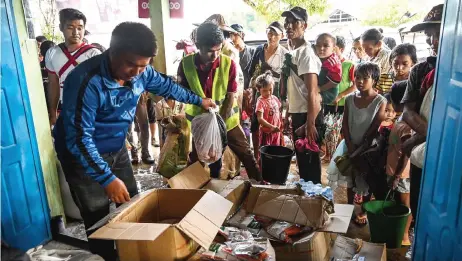  ?? — AFP photo ?? People affected by clashes between the military and ethnic rebel groups wait to receive supplies from local civil society organisati­ons in Man Lwal village, outside Kutkai in Shan State.