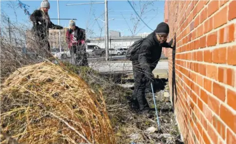  ?? STAFF FILE PHOTO ?? Anna Martino, Balee Price and Michael Harris, from left, pick up trash in a littered lot between 11th and 10th streets as they and other volunteers participat­e in a day of service.