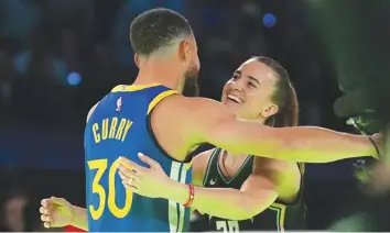  ?? AGENCE FRANCE PRESSE* ?? Stephen Curry #30 of the Golden State Warriors hugs Sabrina Ionescu #20 of the New York Liberty after he wins the Stephen vs. Sabrina 3-Point Challenge shoots a three point basket during the Stephen vs. Sabrina 3-Point Challenge as a part of State Farm All-Star Saturday Night at Lucas Oil Stadium in Indianapol­is, Indiana.