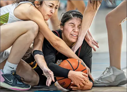  ?? JIM WEBER/NEW MEXICAN FILE PHOTO ?? TOP: Santa Fe Indian School forward Emma Lewis, center, struggles for a loose ball against Pecos’ Angel Montoya during the Al Armendariz Tournament in December. Though keeping up with sports and other responsibi­lities may take a lot of time, for some athletes, sports are the main motivation to do well in school.