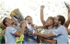  ??  ?? ROME: Lazio’s captain Senad Lulic, center, raises the trophy at the end of the Italian Super Cup final match between Lazio and Juventus at Rome’s Olympic stadium, Sunday. Lazio won 3-2. — AP
