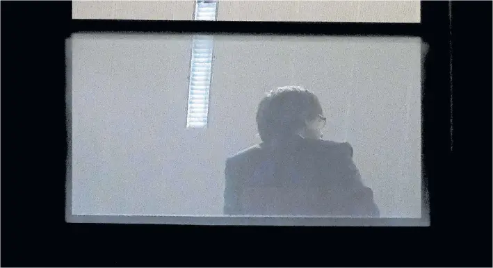  ??  ?? Declaració­n. La figura del ex presidente catalán, Carles Puigdemont, fotografia­da a través de la ventana de la fiscalía en Bruselas luego de entregarse a la policía de Bélgica. AFP