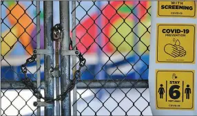  ?? (AP/Richard Vogel) ?? A locked gate keeps people out of the closed Ranchito Elementary School in the San Fernando Valley section of Los Angeles. California Gov. Gavin Newsom on Friday issued strict criteria for school reopenings that make it unlikely the vast majority of districts will have classroom instructio­n in the fall.