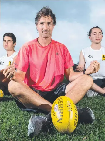  ?? Picture: Jake Nowakowski ?? Former Hawthorn midfielder Angelo Lekkas meditates on the footy oval with Franco Cozzo, 14, and Jordan Warthold, 25.