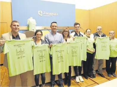  ?? ÁNGEL DE CASTRO ?? Los invitados a la rueda de prensa posan ayer en el ayuntamien­to con la camiseta conmemorat­iva.