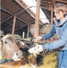  ?? FOTO: BENJAMIN LISS ?? Mit einer Feder verteilt Simone Vogler aus Schöllang im Stall das Räucherwer­k, um das Schlechte in Haus und Hof auszutreib­en und gute Energien zu gewinnen.